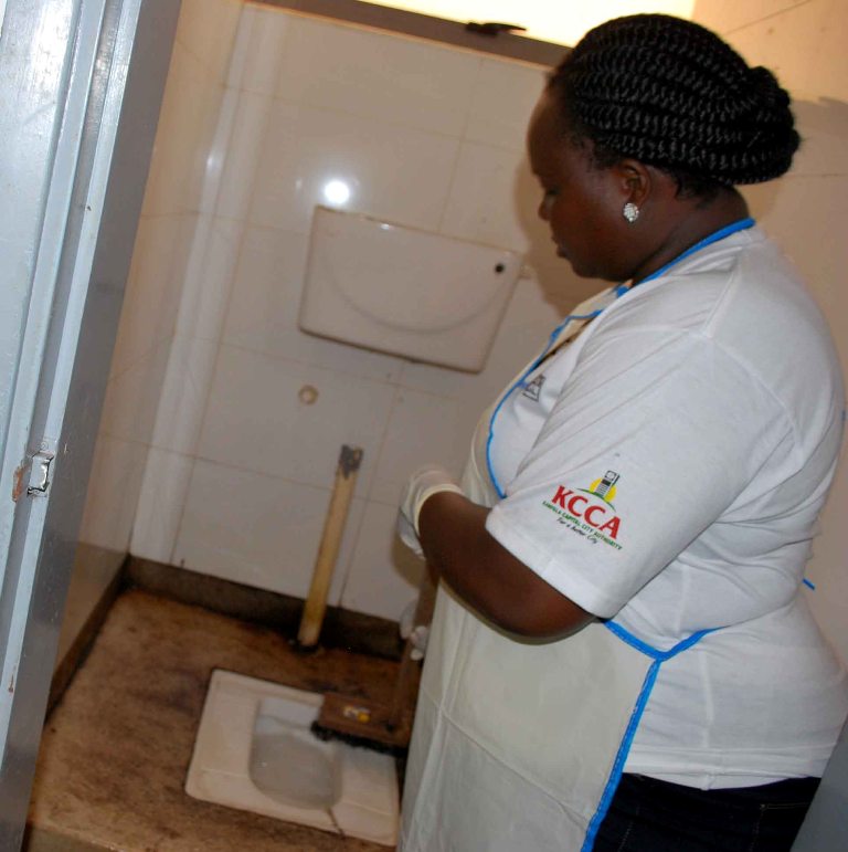 The chairperson of the WASH committee in parliament Jackline Amongin cleaning a toilet ahead of the world toilets day